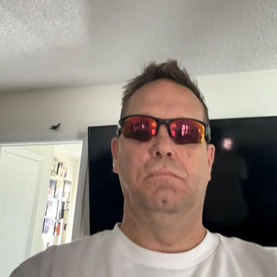 David at home wearing red-tinted sunglasses