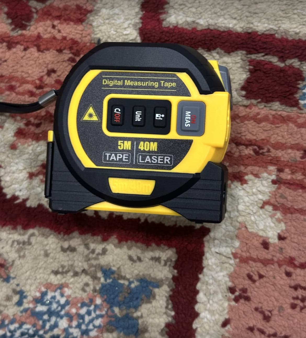 SuperBox tape measure on a patterned rug